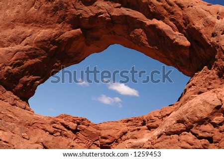 Cosmic eye natural stone arch with blue sky showing through.
