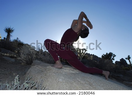 Semi silhouette of Woman in yoga lunge and backbend pose outdoors in the desert.