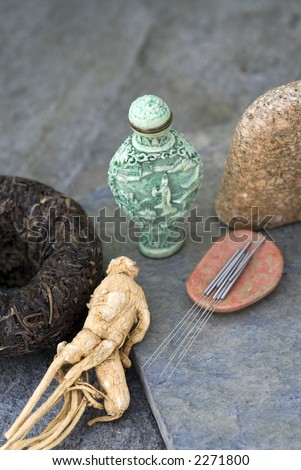 Traditional asian health items:black tea, ginseng, acupuncture needles, and medicine jar.