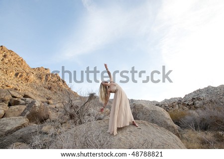 Believe in your Dreams! Big desert sky and a beautiful woman in a formal gown expressing expansiveness in the wide open landscape.