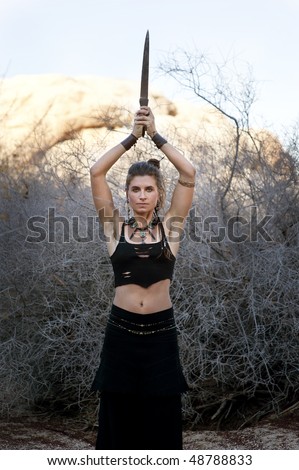 Vision Quest. Wicca Warrior. Woman in the modern tribal adornment style with raised dagger. Warrior goddess.
