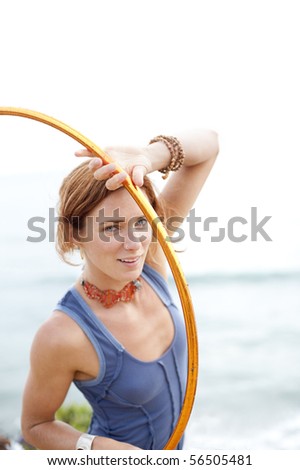 Portrait of a young woman near the beach with her hoop.
