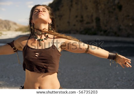 stock photo Woman with arm spread wide wearing a long feather earring near