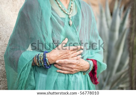 Portrait of a lovely and graceful senior woman\'s hands wearing jewelry by Art Medicine Adornment.