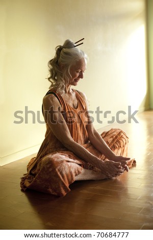 Beautiful mature woman in yoga pose baddhakonasana.