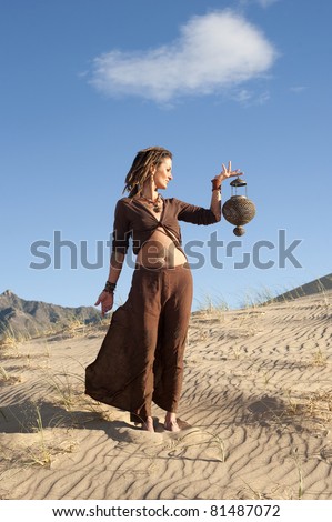 Be your own genie! Unique woman holding a lamp in the desert.