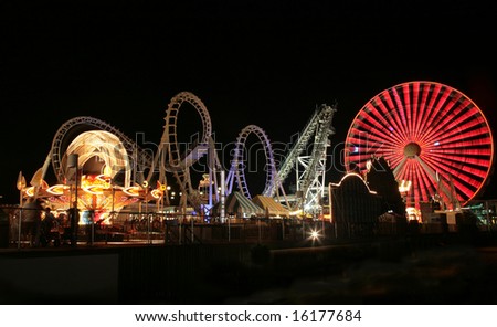 Blurry / long exposure image of a brightly lit amusement park rides
