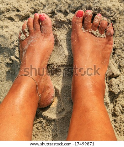 Womens sandy feet on beach