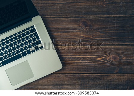 Laptop keyboard on the brown wooden desk