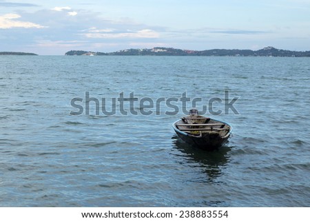 Boat alone on the river forming a clean composition with sea and mountains background