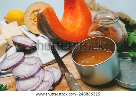 Cooking ingredients, onion, pumpkin, honey, curry, cheese, parsley, lemon, zucchini on the cutting desk with cooking knife