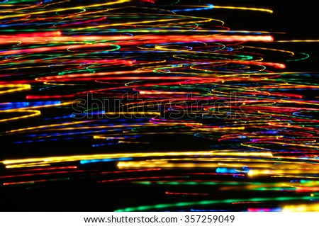 Abstract multicolored light beams in motion, light painting on a black background. Rainbow and chaos