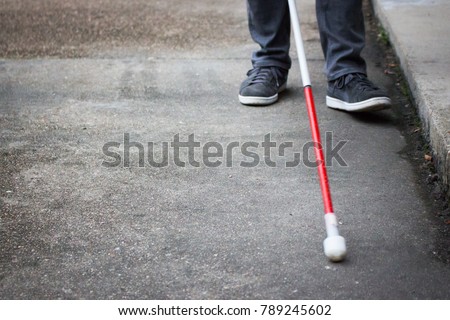 Well Dressed Blind Man Walking Near a Curb with a Long White Cane; Close up on Cane and Feet (Copy Space)