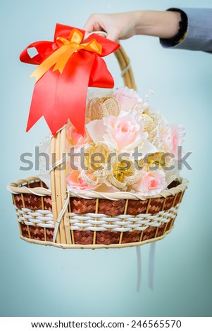 Woman hand holding a basket of flowers