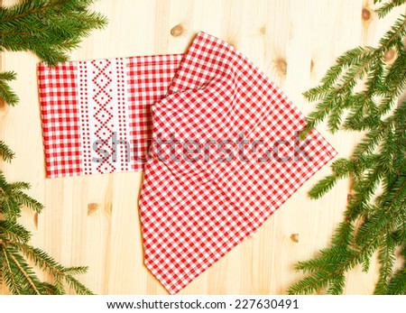 towel white red squares on wooden background with spruce branches