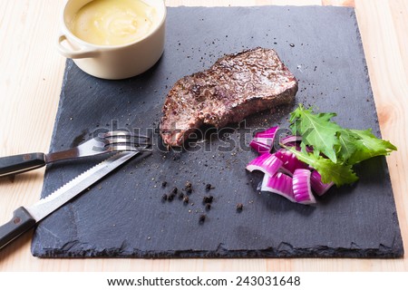 Steak on serving slate plate, medium, potatoes
