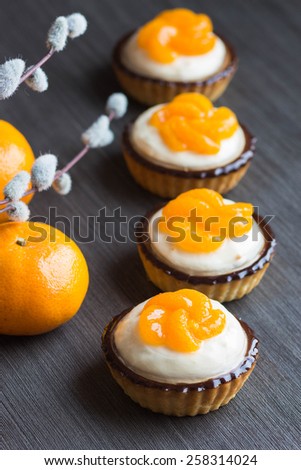 Small cakes with tangerine slices, selective focus to the first cake
