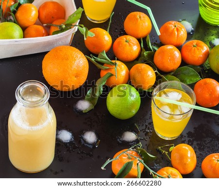 Glasses of juice with leafs and fruits on black background, top view, selective focus