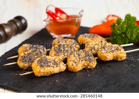 Sesame and chia seed nuggets (ovo-vegetarian) on the wooden sticks, selective focus