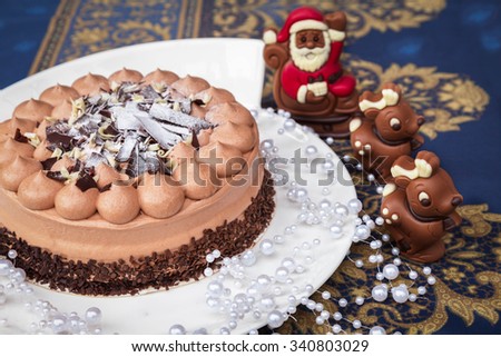 Three chocolate (dark, milk and white) cake on Christmas plate. Chocolate santa Claus and reindeer