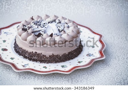 Three chocolate (dark, milk and white) cake on Christmas plate, vintage, toning