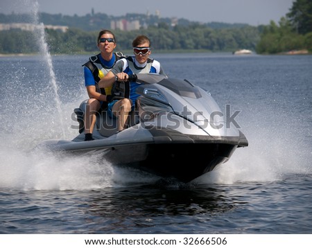 Couple men on jet ski in the river and one of man shows his tongue