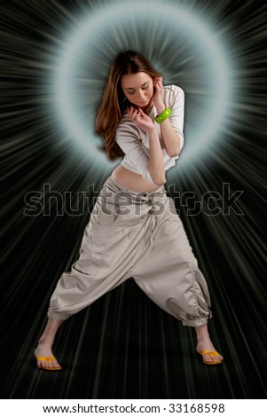 Dancing young girl in light halo and beams