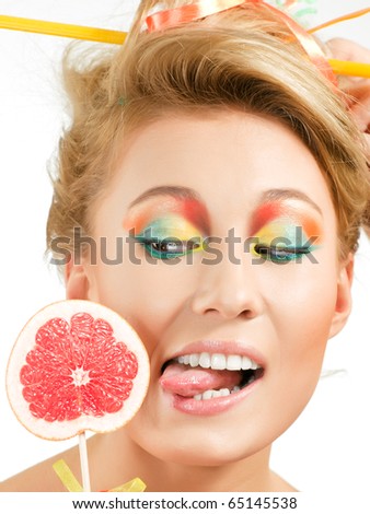 stock photo Beauty young girl tries to lick an round piece of grapefruit 