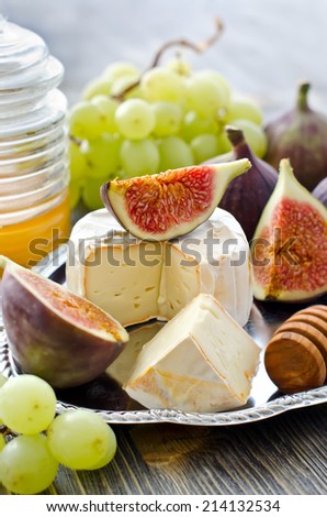 Cheese with fruits on a tray, selective focus