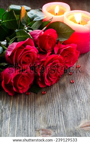 Roses and candles copy space wooden background