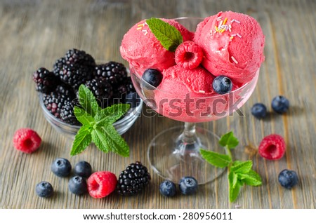 Red ice cream with blackberries, blueberries, raspberries, sorbet, healthy dessert summer food, dark rustic wooden background with berries, sorbet, healthy dessert summer food