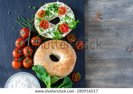 Bagels sandwiches with cream cheese, tomatoes and chives for healthy snack copy space