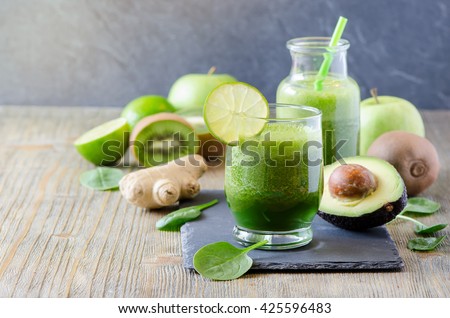 Green fresh detox vegan smoothie, healthy beverage, vitamins diet drink with spinach, avocado, lime, ginger, kiwi, apple. Morning organic drinking