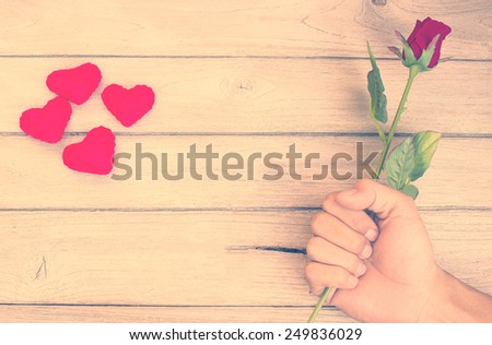 vintage The feeling of love,Rose in hand and heart  on wood