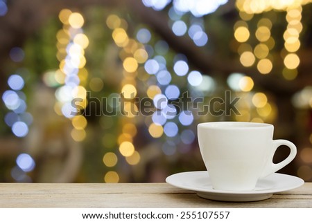 coffee cup on wood table with blur bokeh lights Background