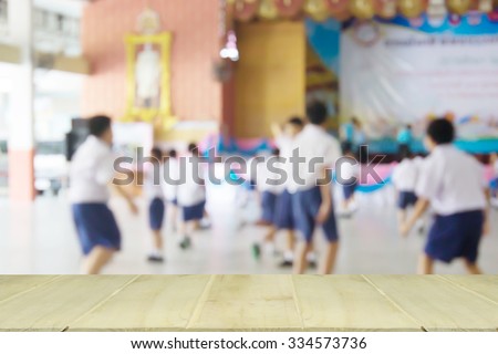 soft focus wooden table with blur of student playing  in school
