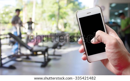 Mobile hold in hand with blur fitness gymt