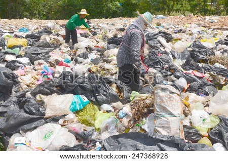 Employees and Scavengers are processing waste in Dump site at Ratchaburee City Thailand on May 6, 2012. People searching for refuse to recycle or resell