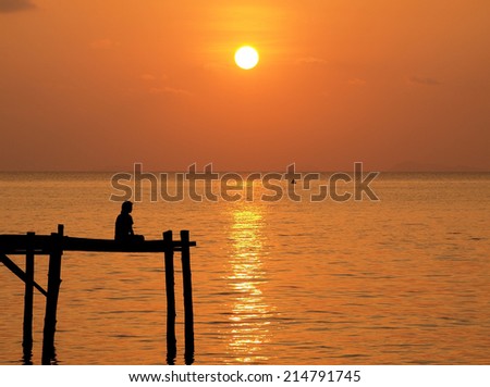 Meditation man sit on wooden pier with sunset sea