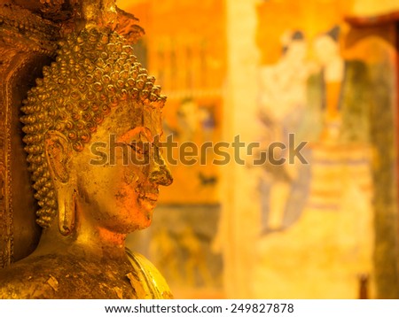 NAN, THAILAND - JANUARY 25: Golden buddha statue with famous mural (wall painting) inside main church of Wat Phu Mintr, Thailand, was taken on January 25, 2015.