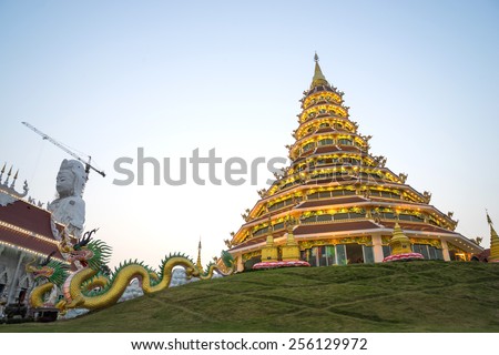 Chinese style nine level pagoda with dragon stairs in Thai temple under twilight sky