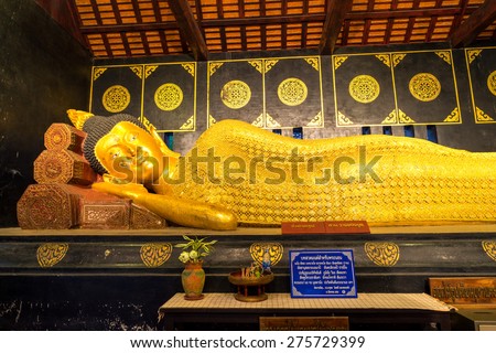 Northern Thai art reclining buddha statue in Wat Jedi Luang in Chiangmai, Thailand. Thai letters mean word of praying, no any trademark or copyright.