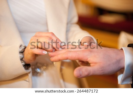 an image of the groom and the bride put on rings in the church