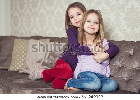 Portrait of two cute sisters at home. Family. Indoor lifestyle portrait of couple beautiful sisters best friends. Cozy home atmosphere