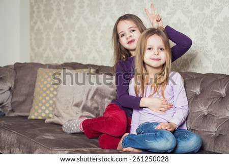 Portrait of two cute sisters at home. Family. Indoor lifestyle portrait of couple beautiful sisters best friends. Cozy home atmosphere