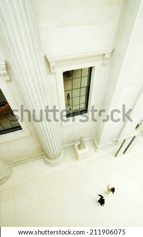 Contemporary classical architecture, London. A high view looking down at anonymous tourists admiring the classical architecture of a renovated London building.