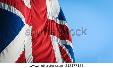 The UK Union flag, often referred to as The Union Jack, flying against a blue sky.