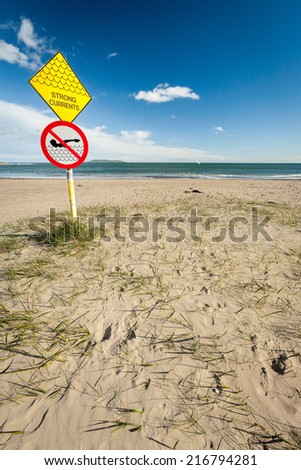 A sign at a sandy beach near Malahide, Ireland, warning people of the strong currents expected in the nearby waters.