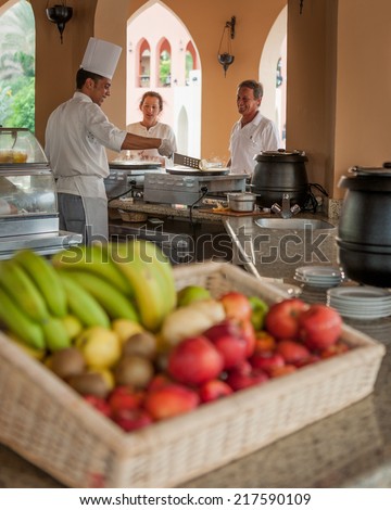 HURGHADA, EGYPT - NOVEMBER 22, 2006: A chef in a luxury resort hotel serving up a freshly cooked breakfast to some waiting guests.