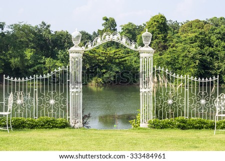 white iron gate and fence in the garden.